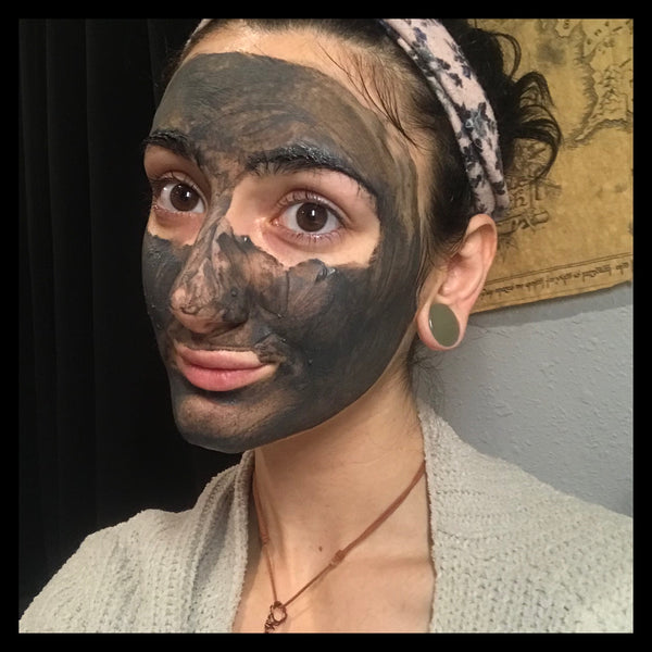 woman with black charcoal mask on her face