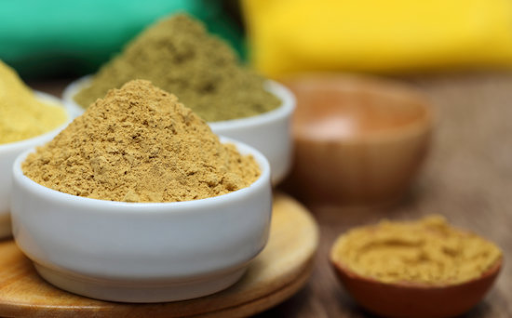 light brown sandalwood powder in a ceramic white bowl