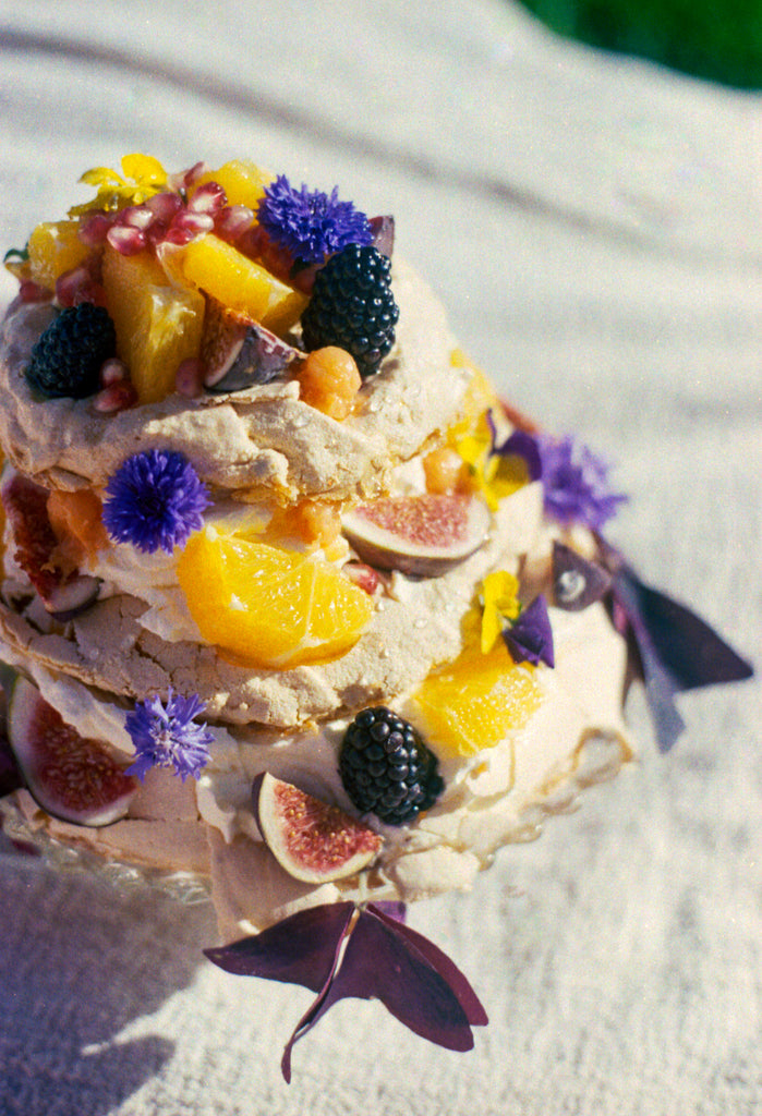 Photo by 0k Studios of emon meringue with an orange sauce and lavender cream.  Decorated with blackberries, figs, oranges, pomegranates, cornflowers and sorrel leaves.