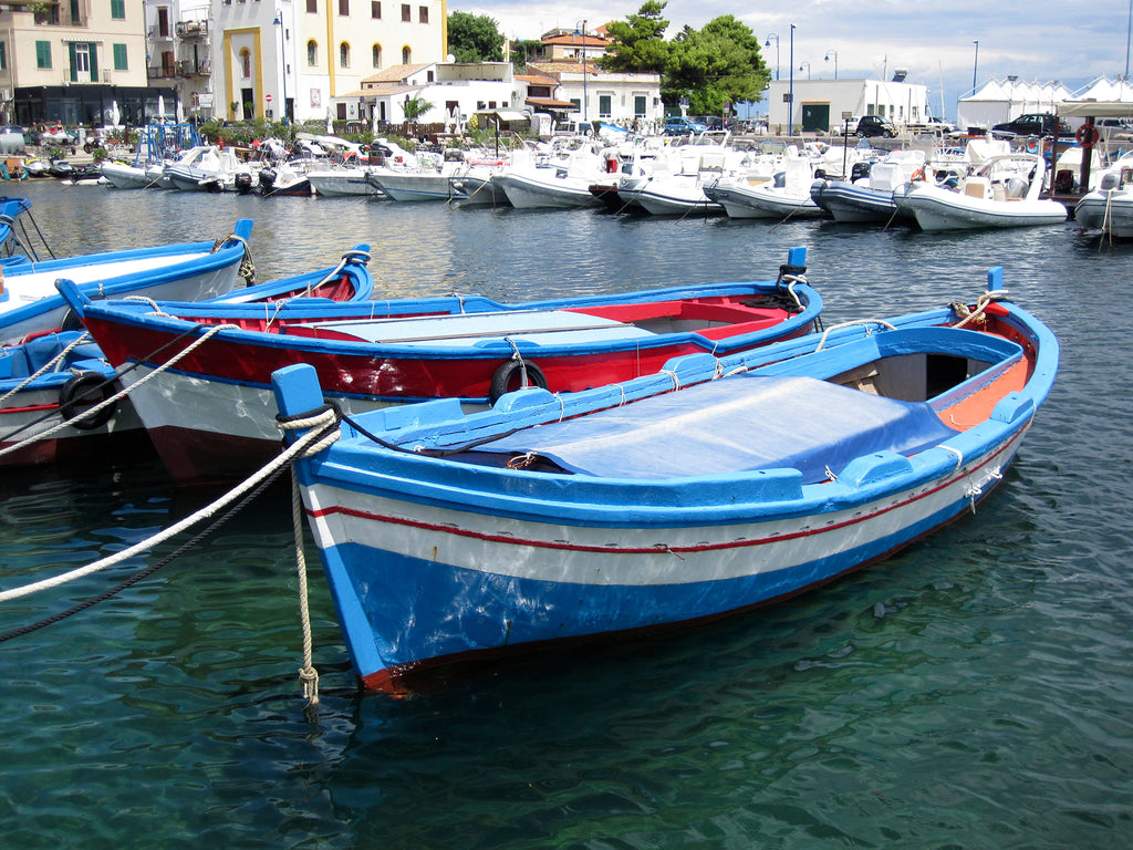 Photo of blue, red and white traditional fishing boats in Sicily.