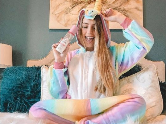 Ragazza si gode il kigurumi unicorno arcobaleno che le hanno regalato