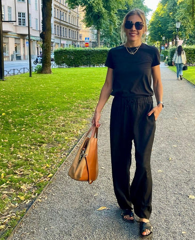 Peppe Öhman walking in Stockholm with her perfect bag: Midi Curie 3-in-1 bag as handbag. Made by genuine leather and suede in color Toffee 