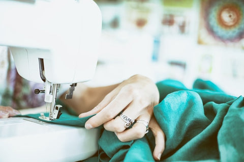 Woman running material through a sewing machine