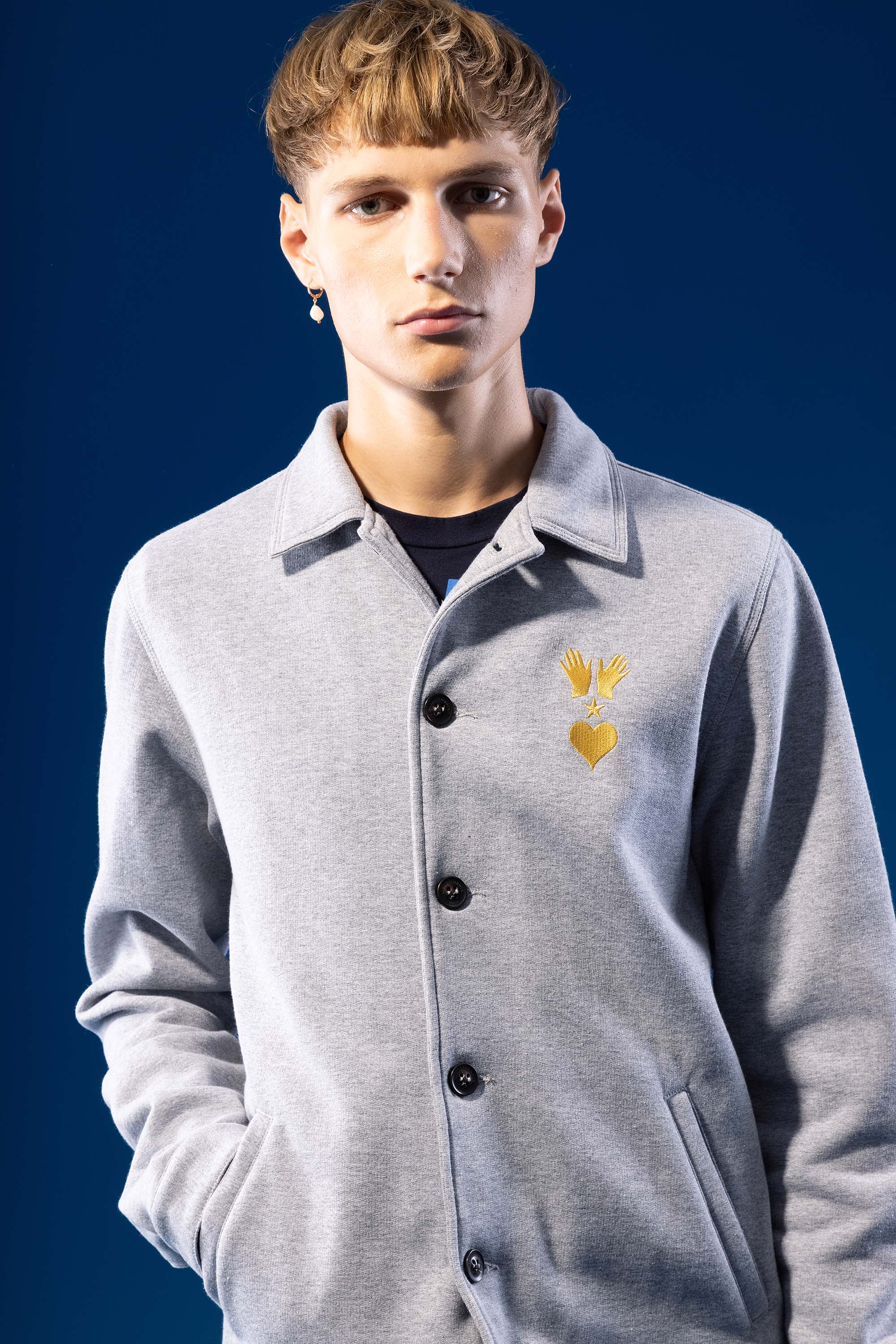 gray cotton buttoned jacket with two outer jersey pockets with classic collar and contrasting embroidery on the chest