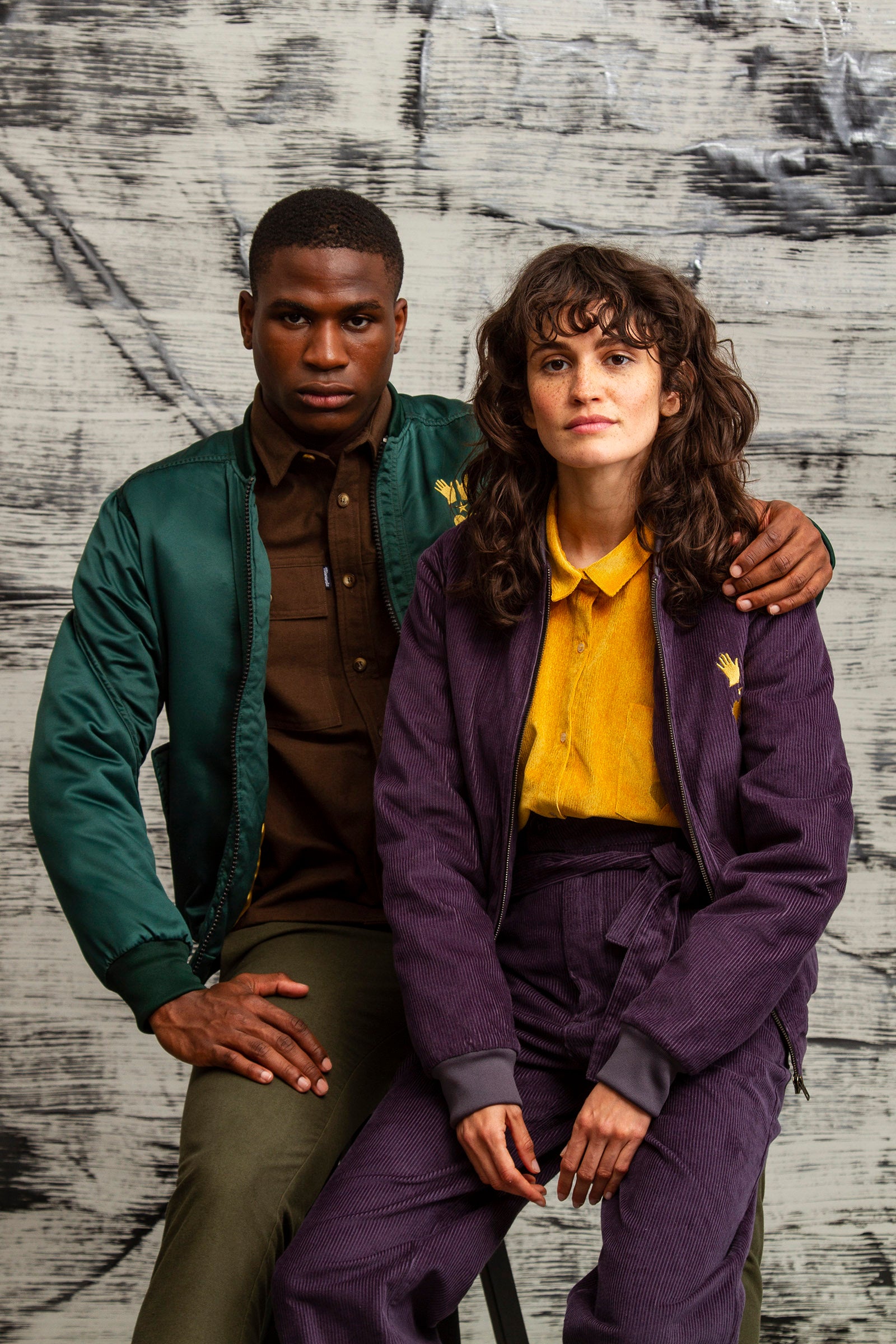 purple polyester satin baseball jacket with ribbed collar and green teddy jacket with volcano embroidery on the back