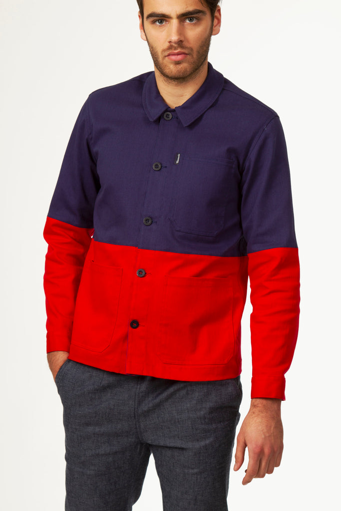 Young man with intense eyes in navy blue and red work jacket in two-tone color block cotton, trendy and casual urban style, quality piece, unique style