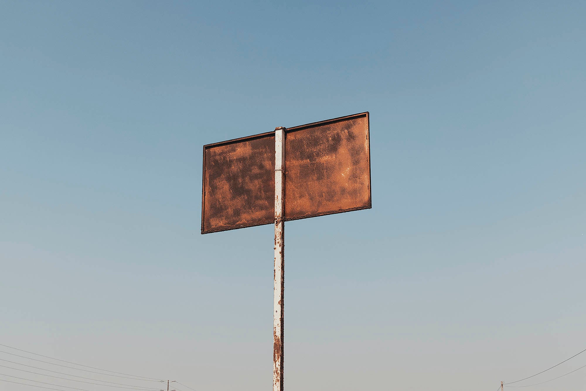 Panneau rouillé pris en photographie sous un ciel bleu au pérou Lima Paysage Bidonvilles ville lumiere architecture desert vague