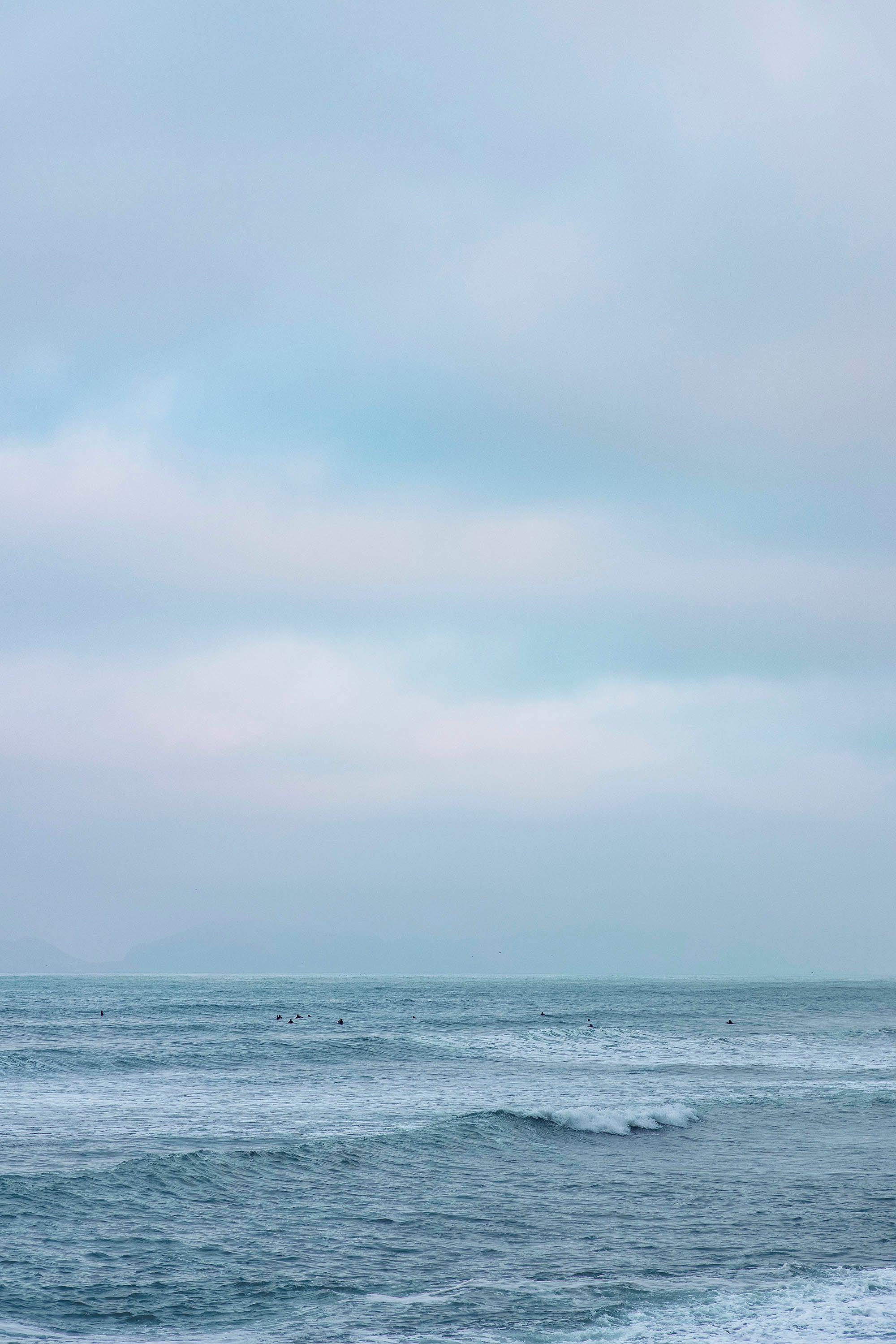 Photograph of the Pacific Ocean in Peru with people bathing in the background Lima Peru Landscape Slums city light architecture desert wave