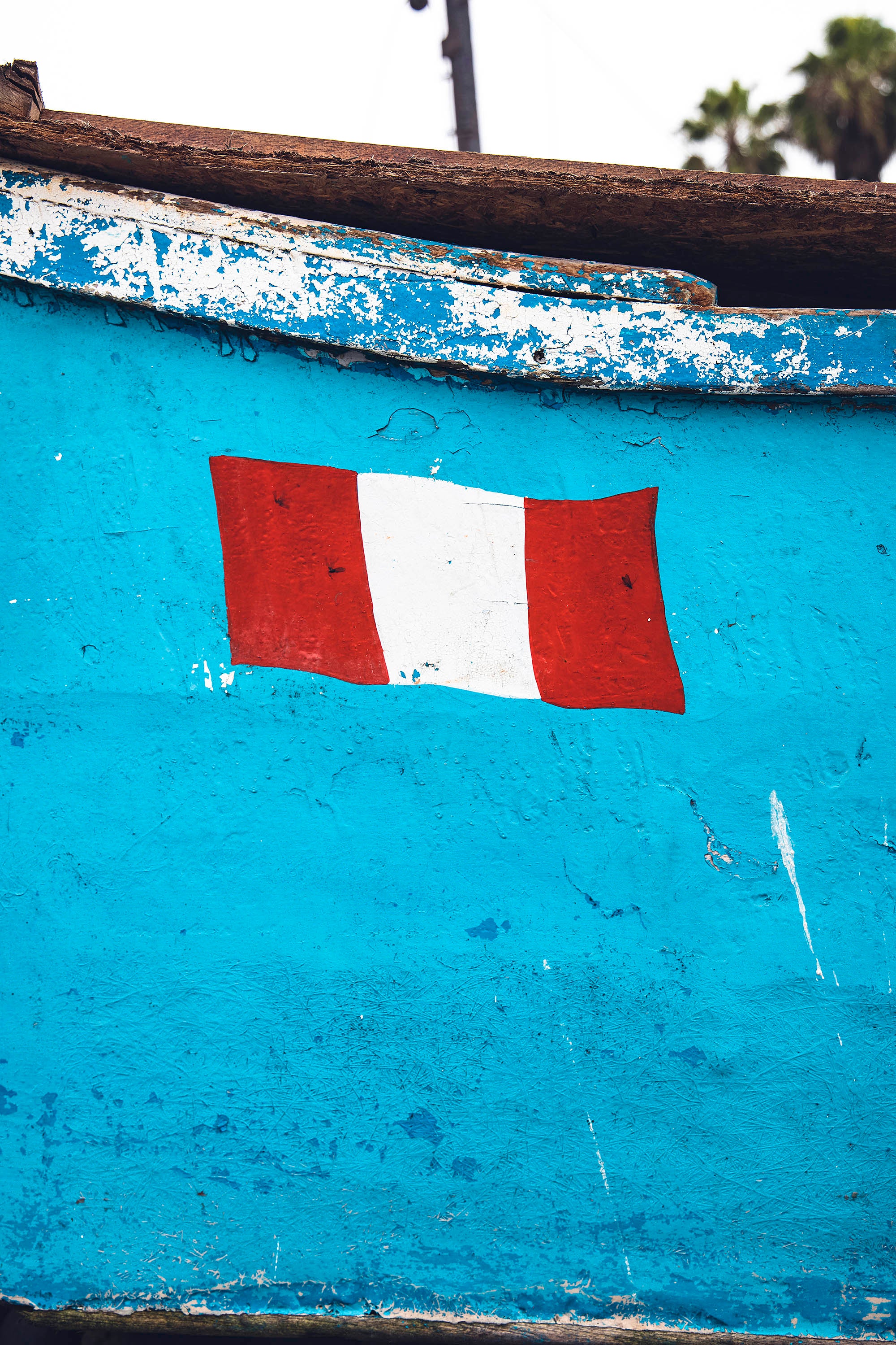 Light blue boat taken in detail during a photograph on which appears a drawing of the Peruvian flag Lima Peru Landscape Slums city light architecture desert wave