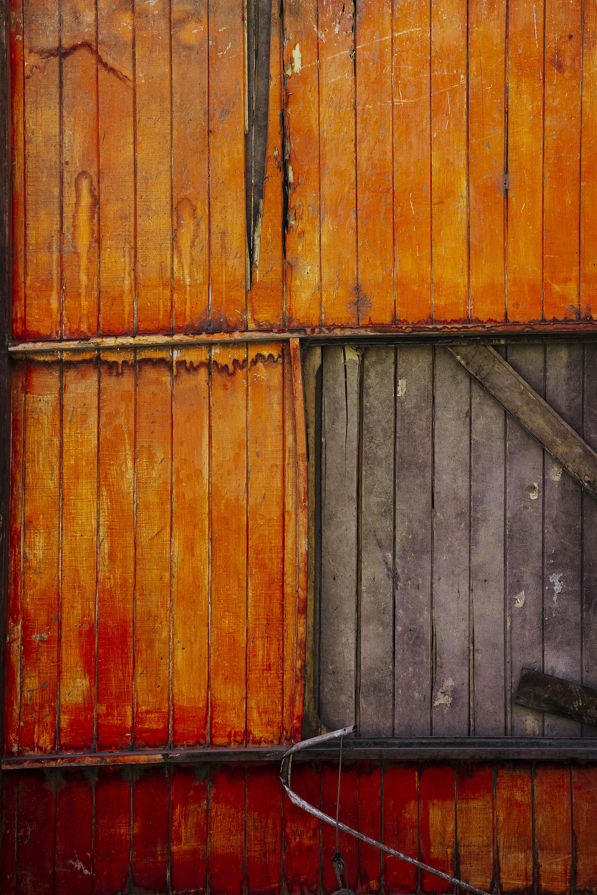 Cabanon en bois orange photographié avec une partie manquant de la peinture
