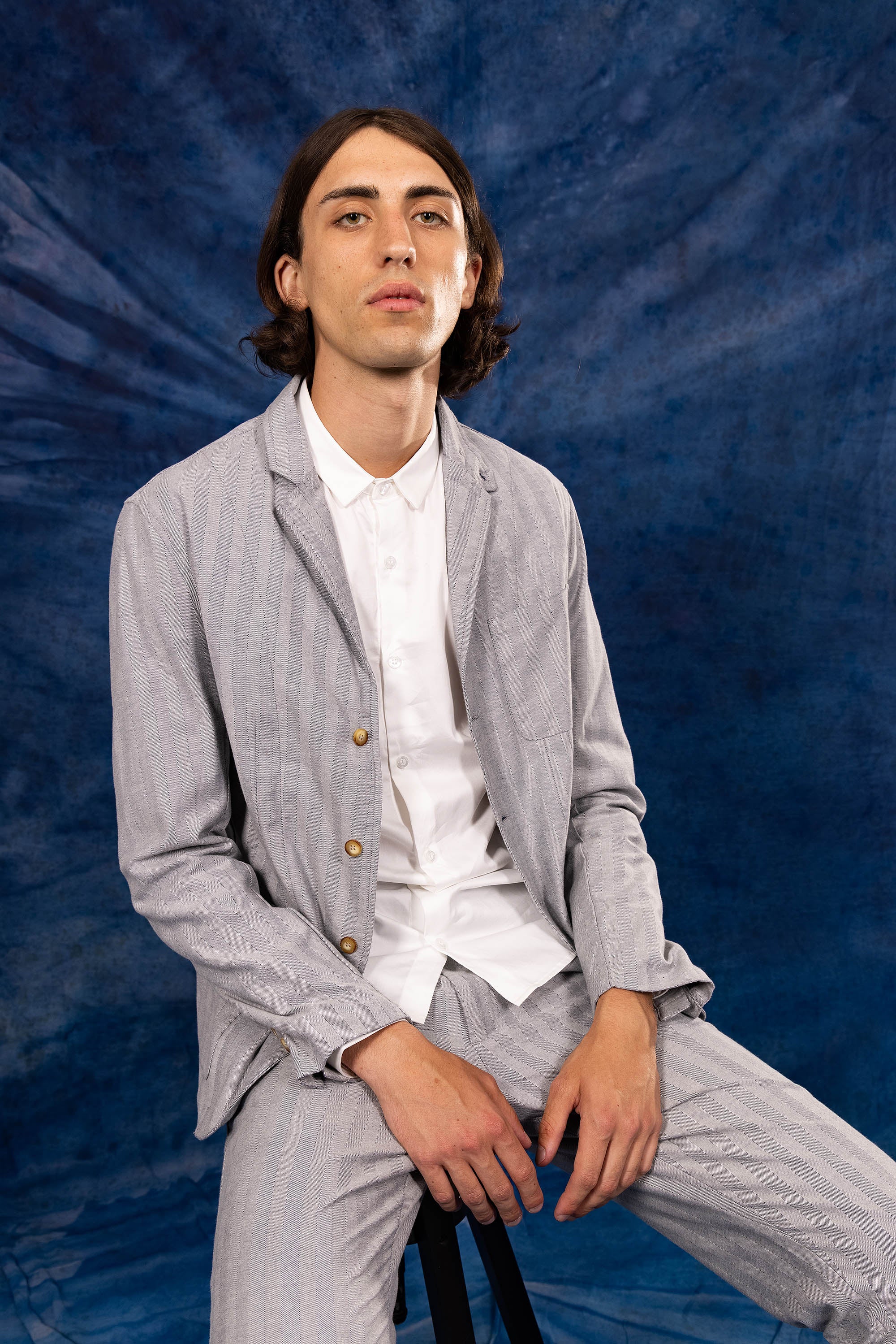 Light gray men's blazer type jacket photography on a blue background new misericordia summer 2023 collection