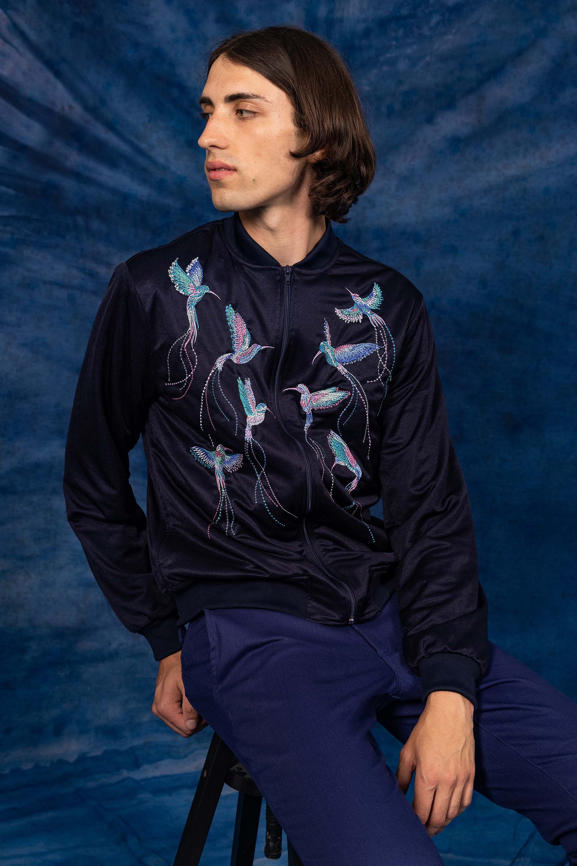 Navy souvenir bomber jacket with hummingbird embroidery on the back, two front pockets and zip closure