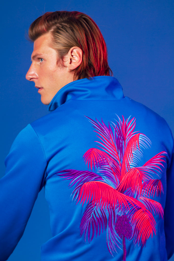 Turquoise blue men's sports jacket in polyester cotton with an embroidered palm tree on the back and misericordia embroidery on the chest