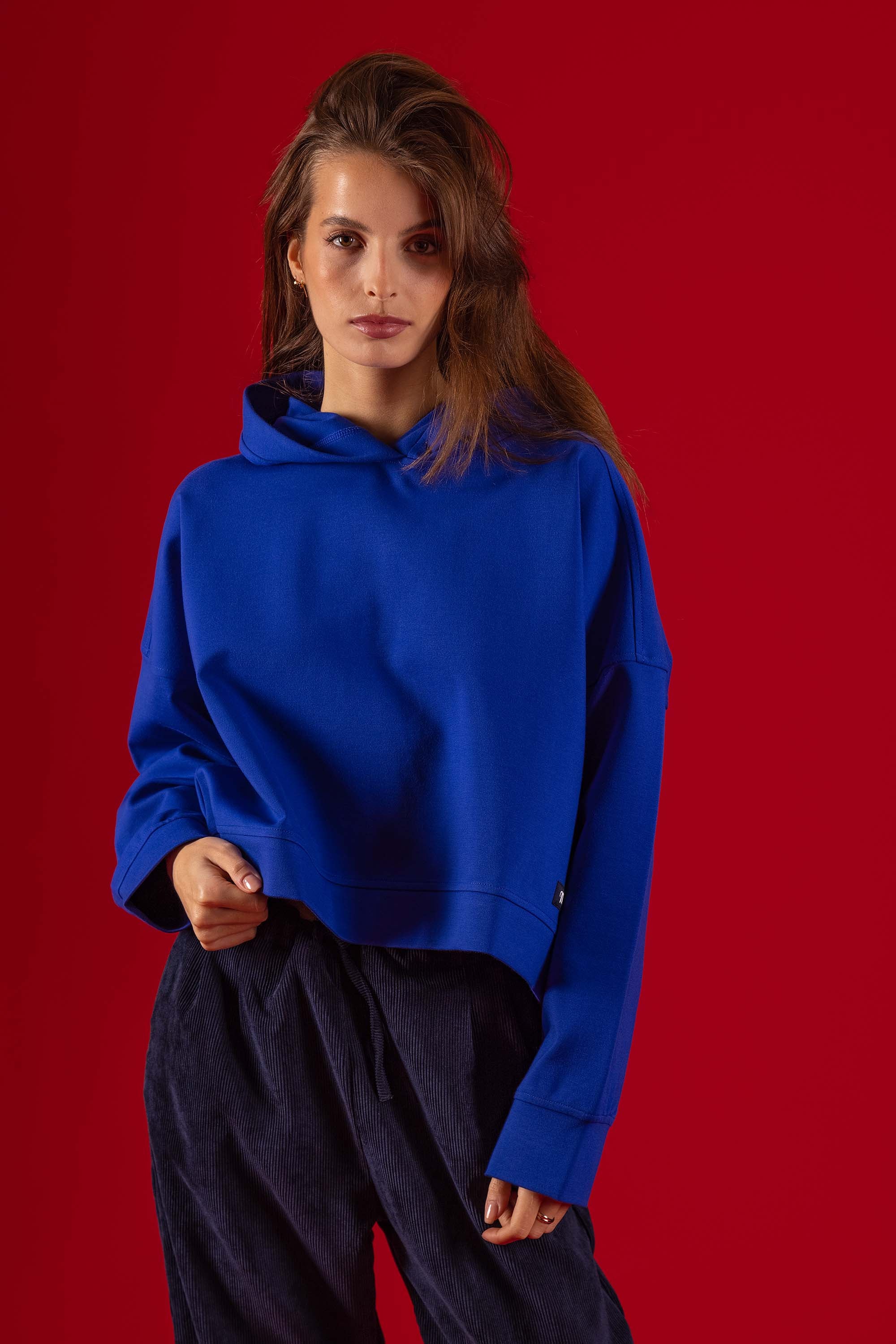Women's cropped sweatshirt with a kangaroo pocket and a sapphire blue hood in technical material