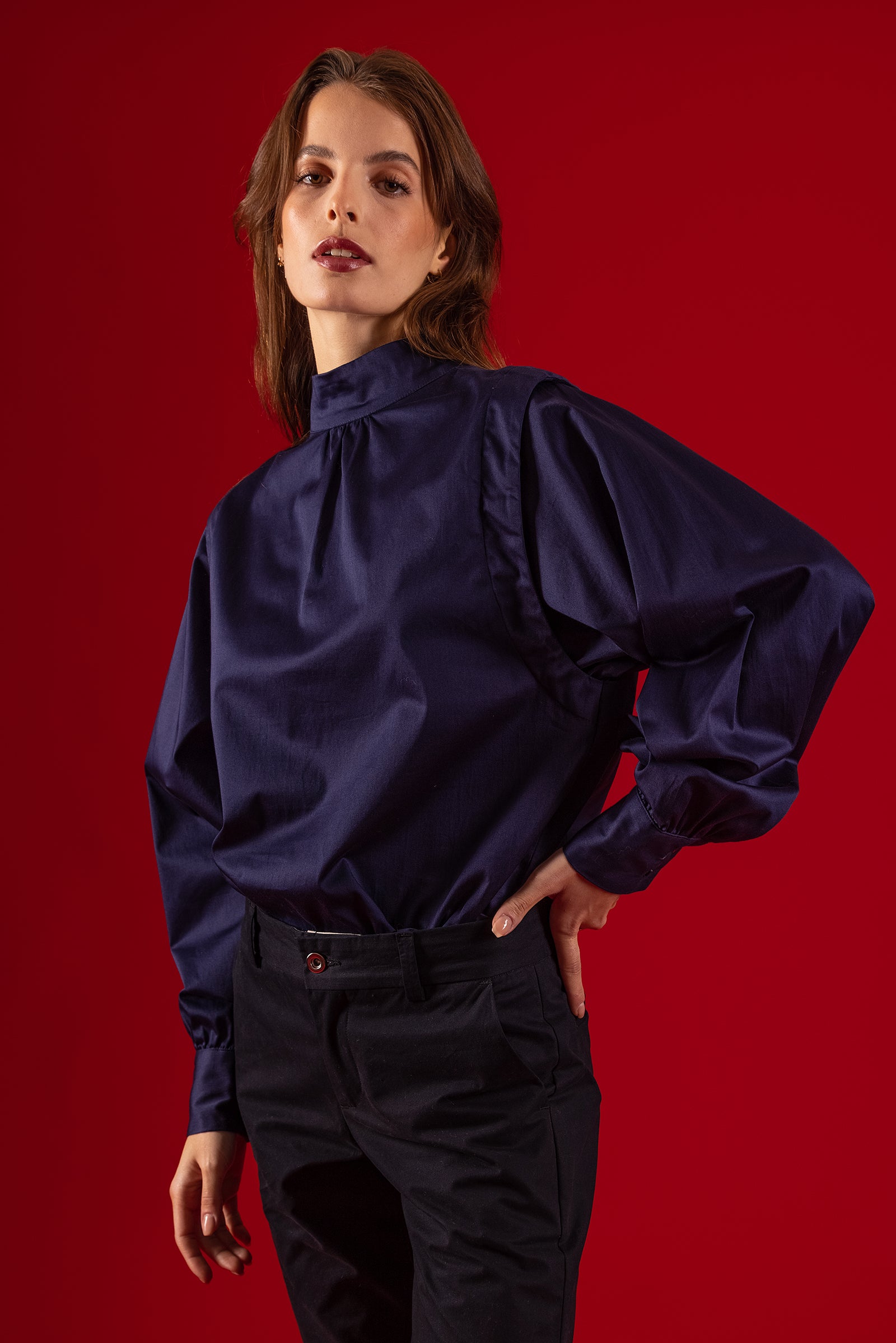 woman wearing navy blue comunion blouse stand-up collar and drop in the back detail delicacy femininity elegance red background stand-up collar long sleeve cotton misericordia lima peru