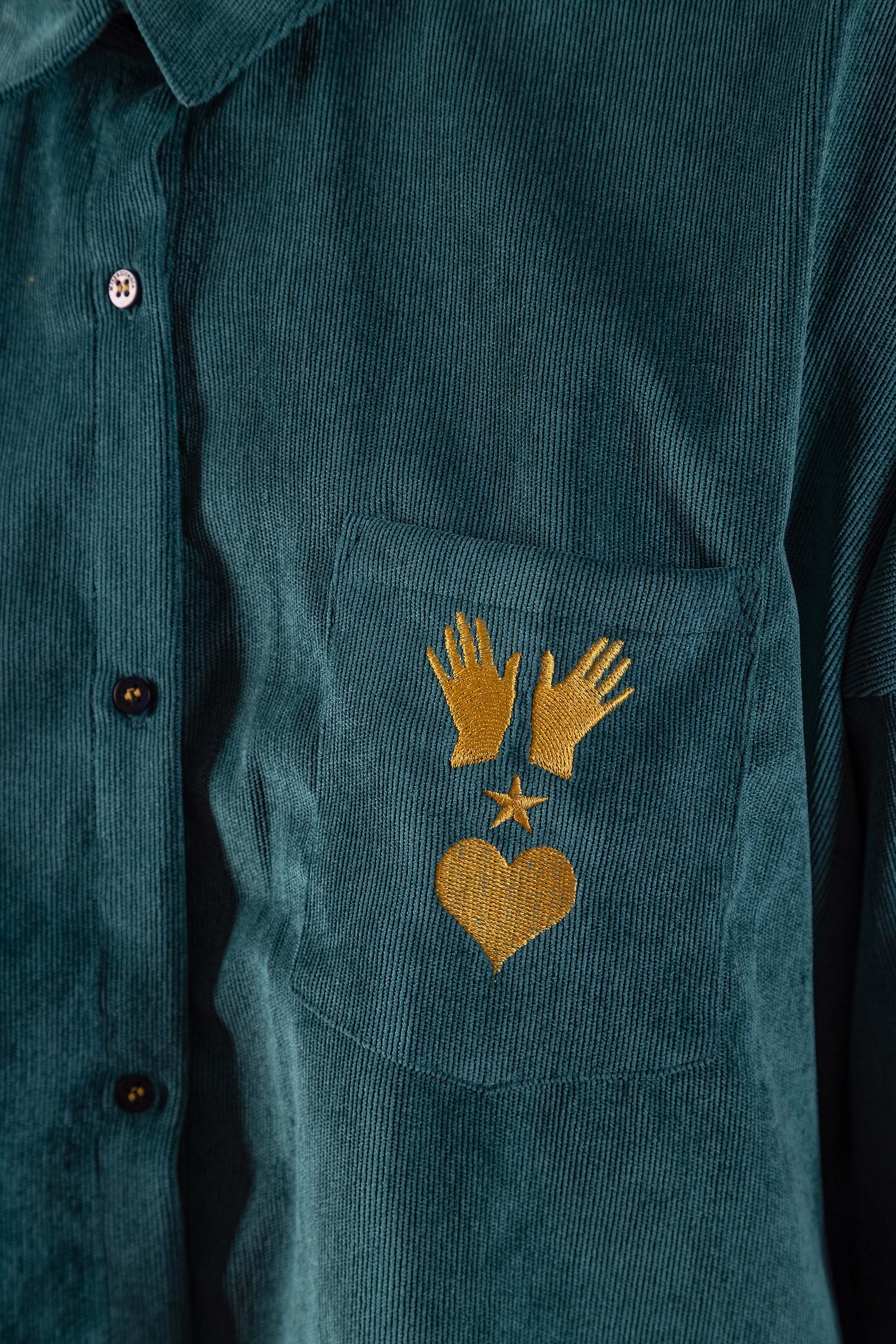 Women's shirt in bottle green polyester velvet embroidered with manos, esperitu y corazon in yellow on the chest pocket