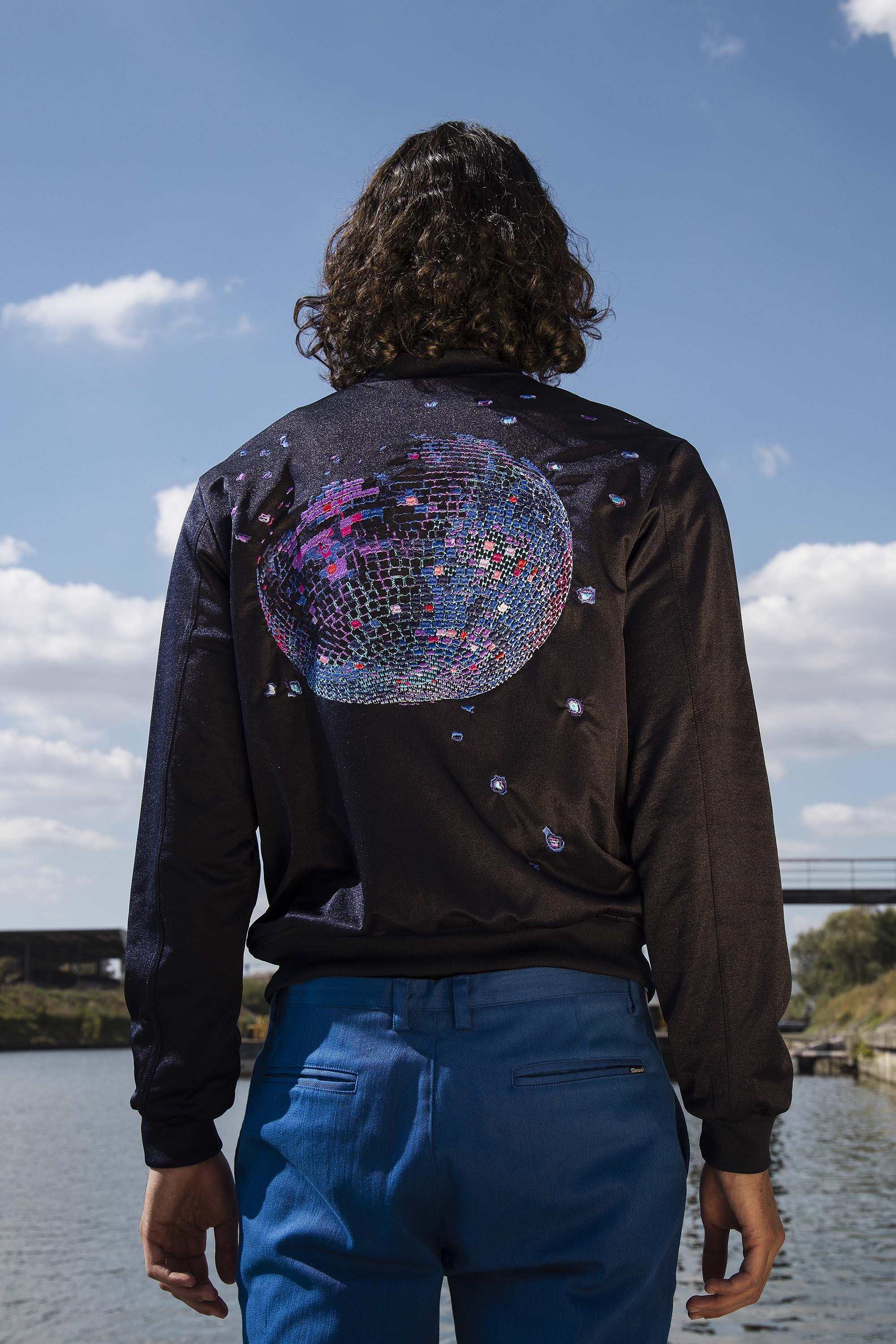 Navy blue polyester souvenir bomber jacket with disco ball embroidery on the back and front pockets
