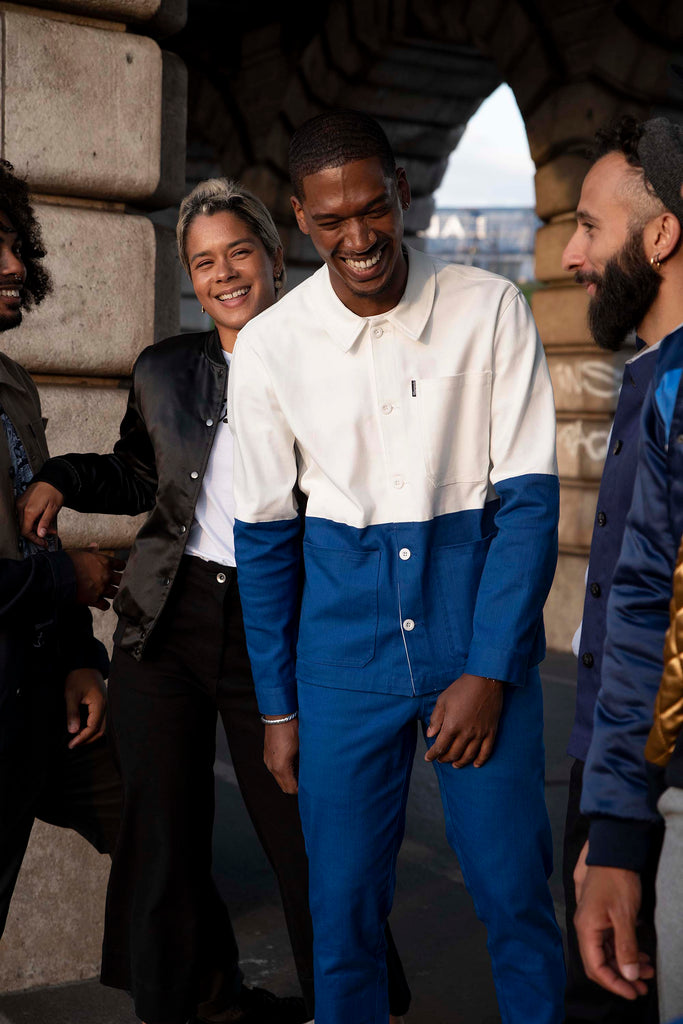 Group of young Parisians laughing, all dressed in sharp, urban pieces, ethical fashion