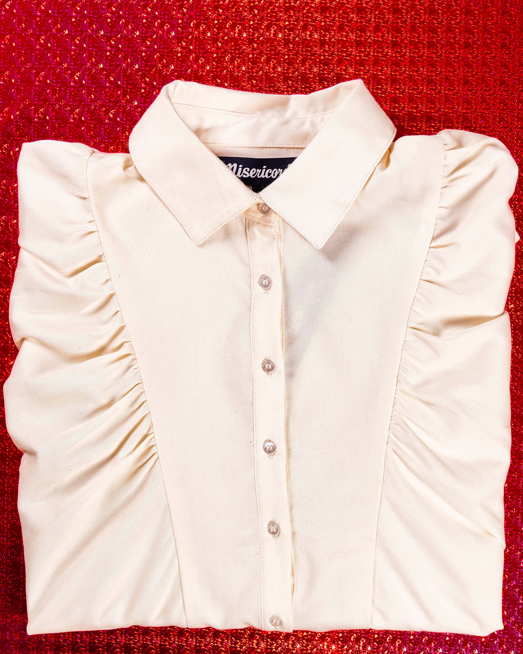 white buttoned balloon sleeve shirt folded on a red background gift idea for christmas