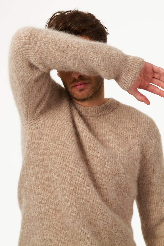 Shy man hiding his eyes in beige sweater in textured knit round neck alpaca wool thick and warm knit to go to work men's trend timeless quality basics