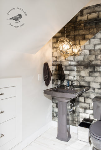 Image of antique mirror tile feature wall, chandelier and built in storage in powder room.