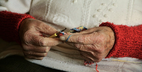 Manos de una señora usando el ganchillo para hacer una labor