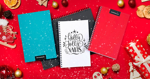 A festive looking arrangement of WTF Notebooks with Christmas decor and snowflakes