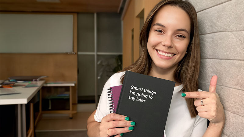A young woman smiling while holding her WTF Notebooks