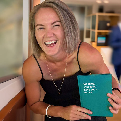 A woman laughing hard while holding her WTF Notebook