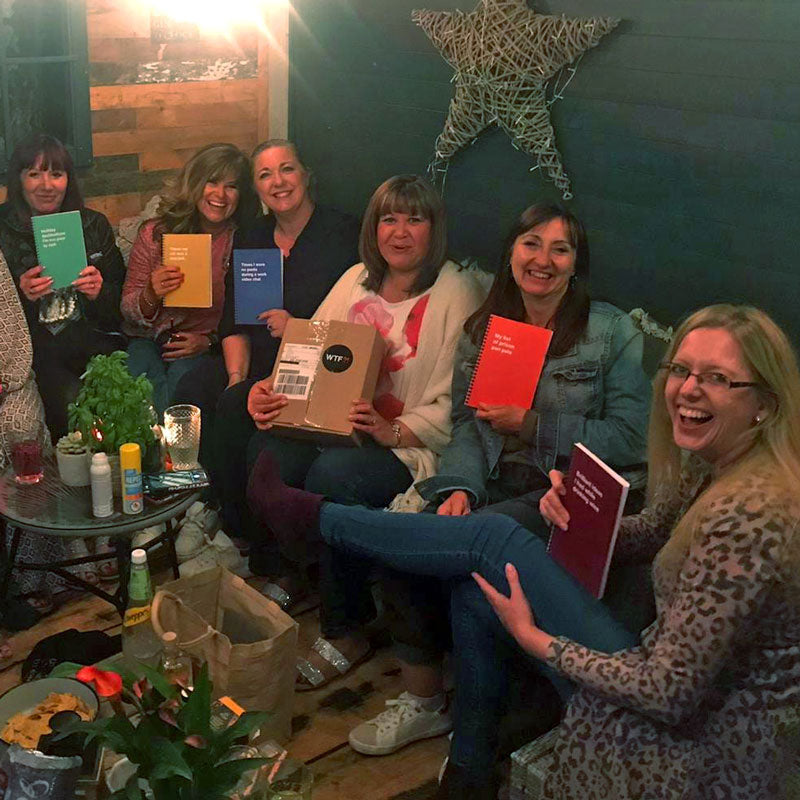 A group of women smiling with their individual WTF Notebooks