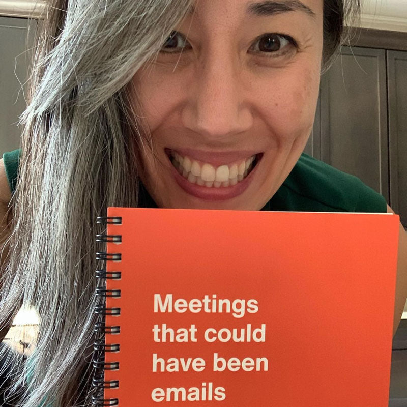 A woman smiling and holding her WTF Notebook