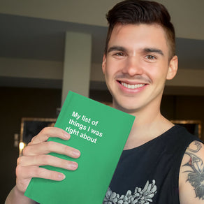 A young man holding up his WTF Notebook funny gift
