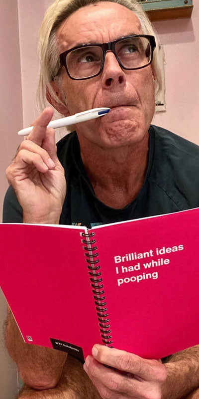 A man contemplating on the toilet with his inappropriate WTF Notebook