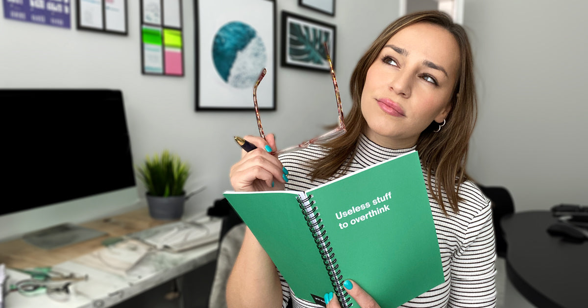 A business woman thinking, holding her WTF Notebook