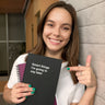 A happy young customer holding her WTF Notebooks