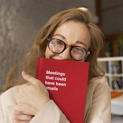 A very happy office worker holding up her WTF Notebook titled 