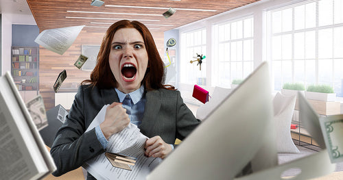 A frustrated business woman screaming with office stationery flying around her