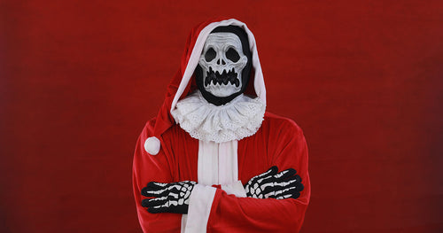 A Halloween-style skeleton wearing a Santa coat
