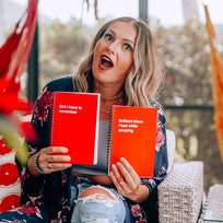 A woman holding two WTF Notebooks