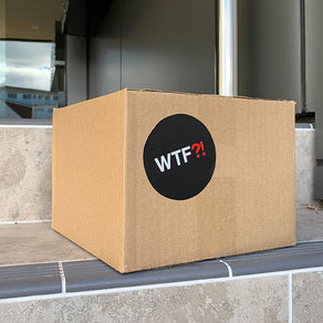 A box of WTF Notebooks by a front door