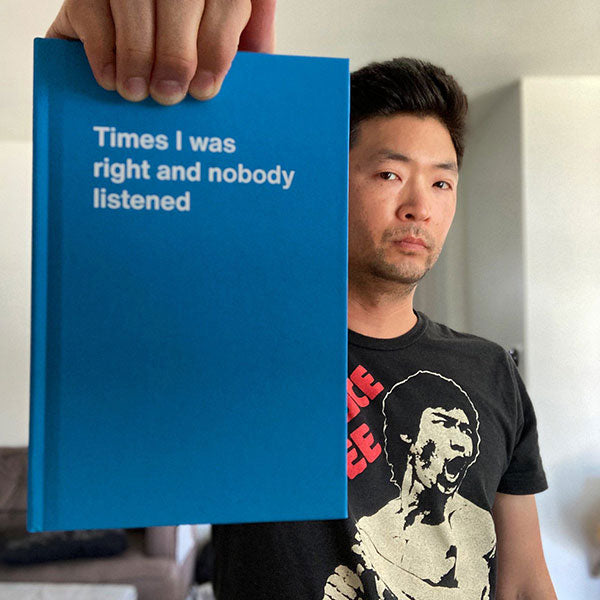 A customer holding his blue WTF Notebook titled 'Times I was right and nobody listened'