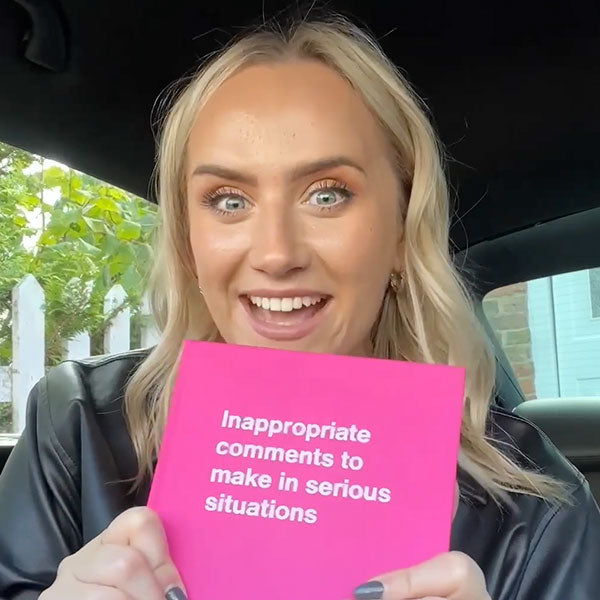 A happy customer holding her pink WTF Notebook 'Inappropriate comments to make in serious situations'