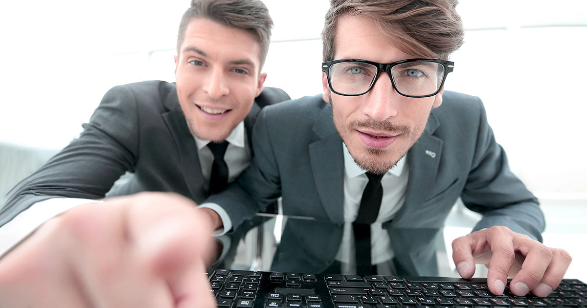 Two business men looking sceptically at their computer