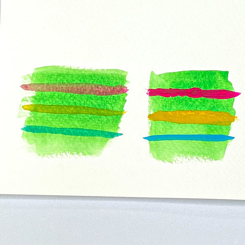 Two painted squares of Green watercolor with pink, yellow and teal stripes across each square.  
