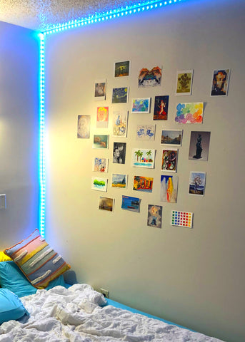 college apartment bedroom with postcards displayed on the wall as decoration