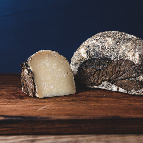 This wheel of Pecorino Foglie Di Noce has developed a natural rind and been coated with olive oil and walnut leaves.