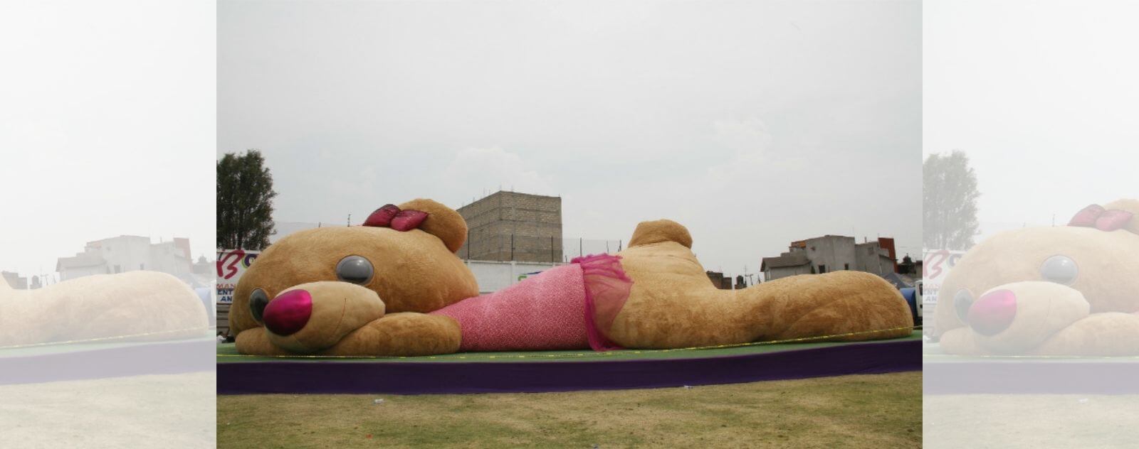 Xonita le Plus Gros et Grand Ours en Peluche du Monde avec sa Robe Rose, son Noeud Papillon et ses Gros Yeux