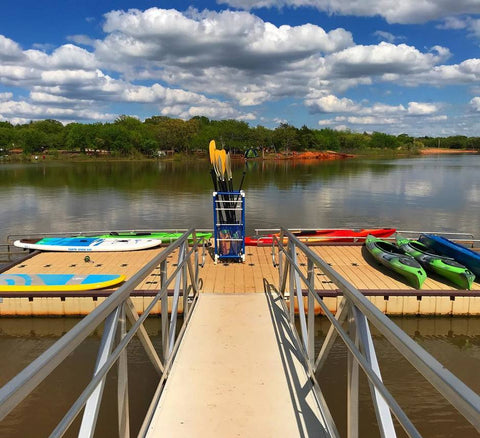 paddle boards and kayaks on a dock