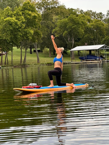 women practicing sup yoga on a paddleboard