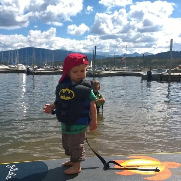 child on a stand up paddle board